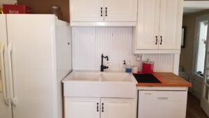 Farm sink, dishwasher, and side-by-side fridge in kitchen